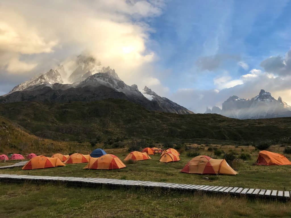 Orange tents set up below a mountain in Torres del Paine