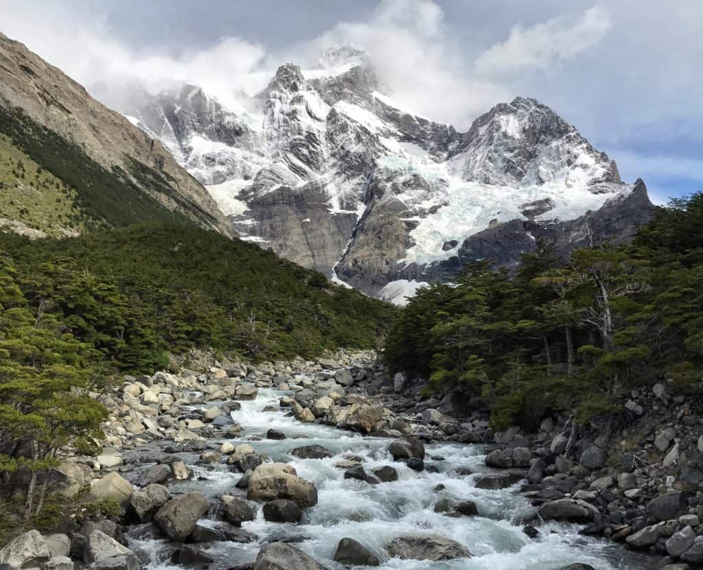 White capped mountain behind an alpine river in Patagonia