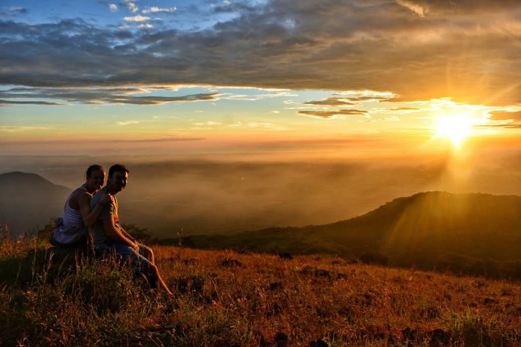 Kyle and I watching the sunset during el hoyo backpacking trek, orange skies with the sun setting over volcanos