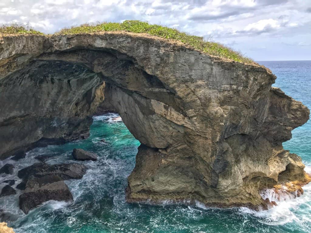 visit puerto rico, cueva del indio, rock formation over turquoise water