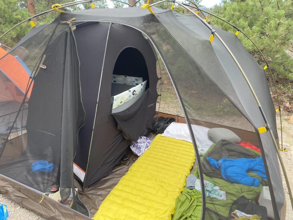 Sleep set up to camp with a 1 year old. Large tent with tent pads, pack n play, and slumber pod.