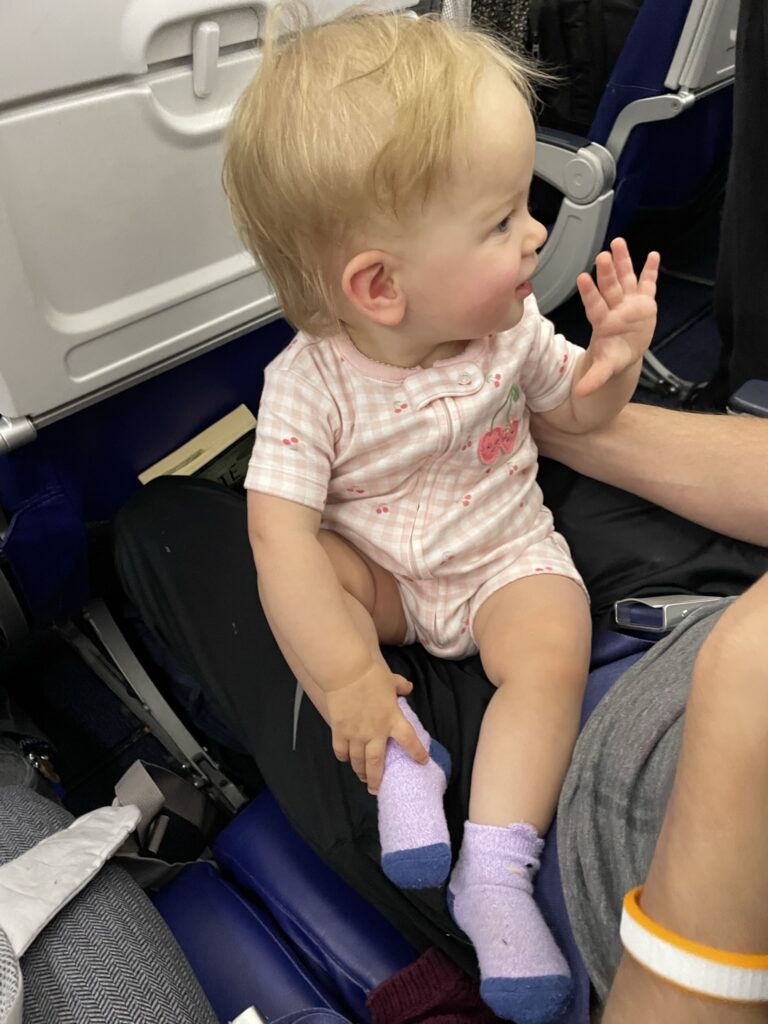 Infant waving on plane.